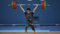 Atlet angkat besi Indonesia, Rizki Juniansyah berhasil mengangkat beban seberat 199 kg pada angkatan clean and jerk saat berlomba pada kelas 73 kg putra cabor angkat besi Olimpiade Paris 2024 di Paris Expo Porte de Versailles, Paris, Kamis (8/8/2024). (AP Photo/Kin Cheung)