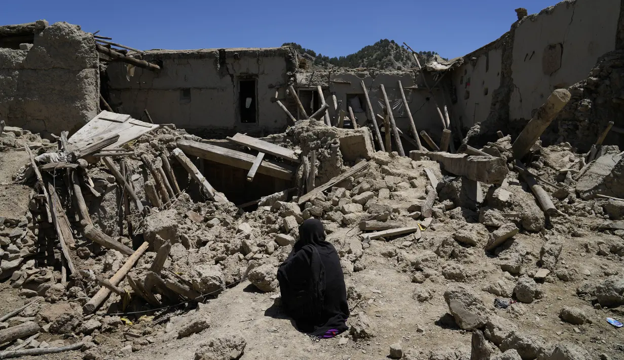 Wanita Afghanistan duduk di tengah kehancuran setelah gempa bumi di desa Gayan, di provinsi Paktika, Afghanistan, Jumat 24 Juni 2022. Lebih dari 1.000 orang dilaporkan tewas dan sedikitnya 1.500 orang terluka dalam gempa bumi dahsyat yang mengguncang Afghanistan pada Rabu 22 Juni 2022 dini hari. (AP Photo/Ebrahim Nooroozi)
