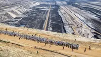 Aktivis iklim berjalan mamasuki tambang batu bara lignit Garzweiler di Garzweiler, Jerman barat, Sabtu (22/6/2019). Ratusan aktivis iklim menduduki tambang batu bara yang dijalankan oleh raksasa energi RWE. (Marcel Kusch/DPA/AFP)