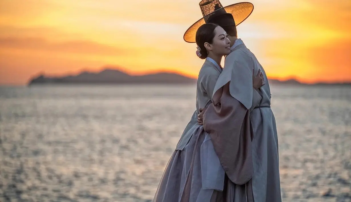 Dengan latar keindahan sunset di pantai Jeju, Rizka dan Sang Ho Han tampil memesona dibalut hanbok nuansa pink pastel. [Foto: IG/rizkanatakusumah].