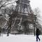 Seorang pria membawa anjingnya berjalan di bawah Menara Eiffel di Paris, Prancis (7/2). Ratusan orang terpaksa meninggalkan mobil mereka untuk tidur di tempat penampungan darurat akibat cuaca ekstrem yang melanda. (AFP Photo / Thomas Samson)