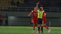 Penyerang Persis Solo, Ramadhan Sananta, harus menerima kartu merah dari wasit Agung Setiyawan yang baru saja meninjau tayangan VAR dalam laga melawan PSBS Biak di Stadion Manahan, Solo, Senin (16/12/2024). (Bola.com/Radifa Arsa)&nbsp;&nbsp;&nbsp;