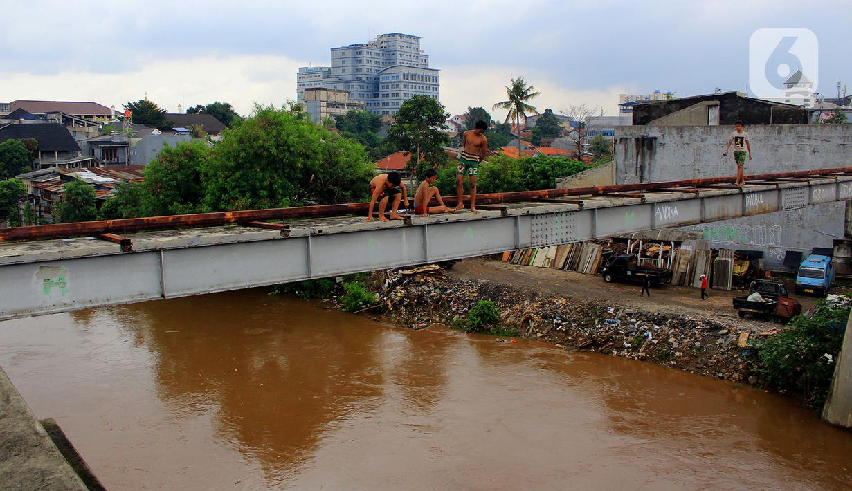 Anak-anak melompat dari jembatan ke Kali Ciliwung Kalibata, Jakarta, Selasa (25/2/2020). Beberapa anak nekat bermain air dengan lompat dari atas jembatan Ciliwung Kalibata, Jakarta, Selasa (25/2/2020). (merdeka.com/magang/Muhammad Fayyadh)