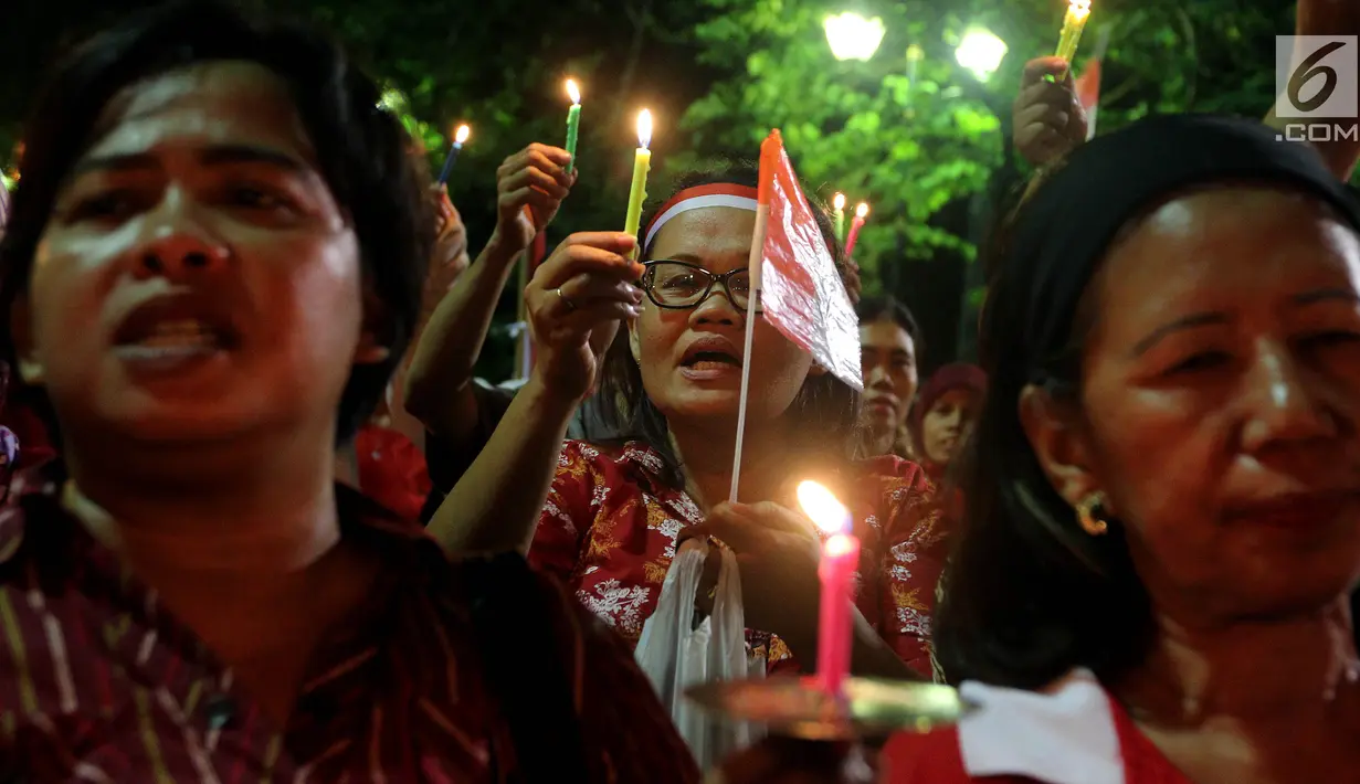 Masyarakat yang tergabung dalam Silent Majority Forum melakukan aksi damai dengan menyalakan lilin di Silang Monas, Jakarta, Kamis (1/6). Mereka menentang segala bentuk perbedaan keadilan oleh kelompok tertentu. (Liputan6/JohanTallo)
