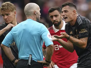 Wasit yang memimpin laga Manchester United melawan Arsenal, Paul Tierney menganulir gol yang dicetak Gabriel Martinelli pada menit ke-12 usai meninjau VAR. Sebelum gol terjadi, Martin Odegaard terlebih dahulu melakukan pelanggaran terhadap Christian Eriksen. (AP Photo/Dave Thompson)