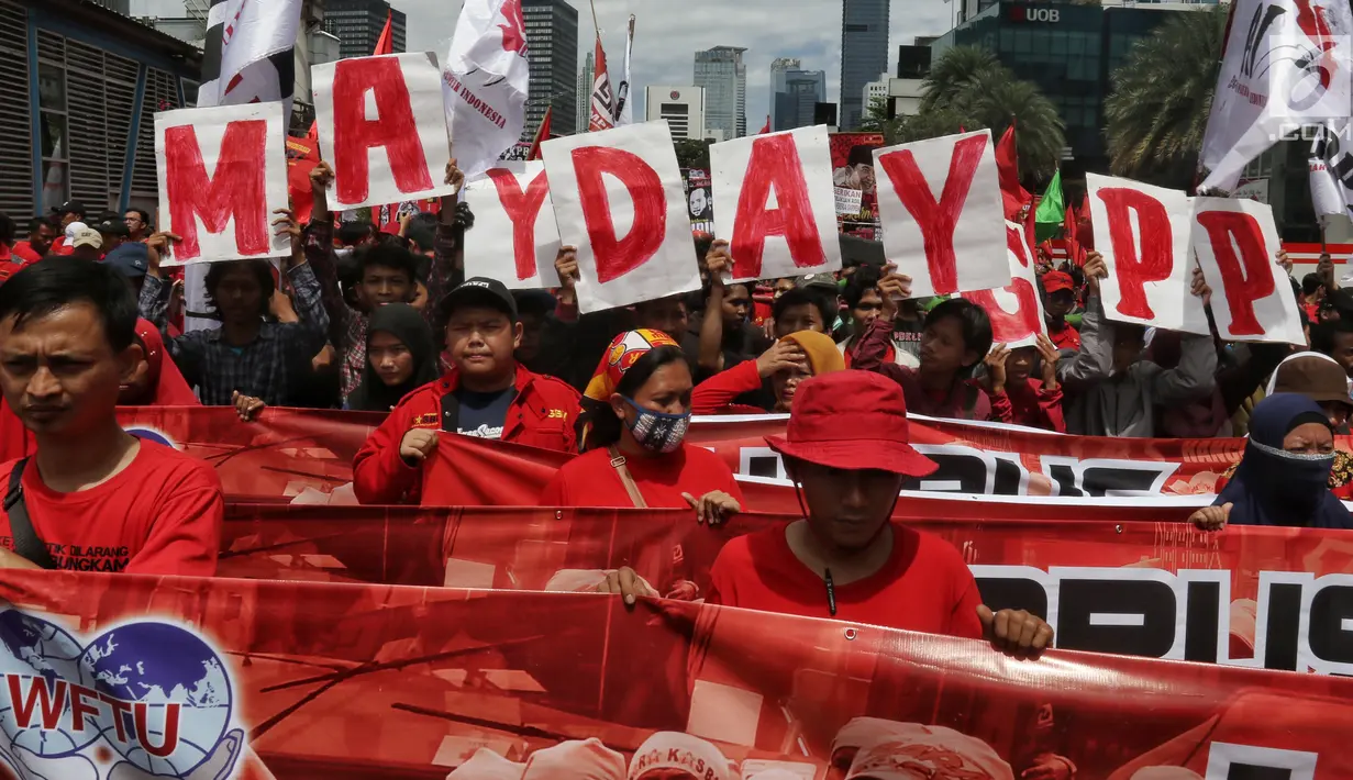 Peserta aksi dari sejumlah elemen buruh membawa poster saat menggelar aksi memperingati Hari Buruh Sedunia di kawasan Bundaran HI, Jakarta, Rabu (1/5/2019). Massa aksi dalam peringatan Hari Buruh 2019 tidak dapat mendekati Istana Merdeka lantaran tertahan di kawasan itu. (Liputan6.com/Johan Tallo)