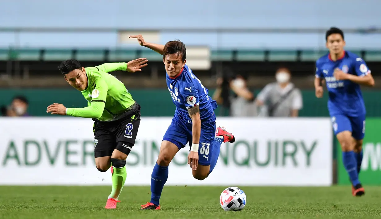 Pemain Jeonbuk Hyundai Motors berebut bola dengan pemain Suwon Samsung Blue Wings pada laga K-League Korea Selatan di Jeonju World Cup Stadium, Jeonju, Jumat (8/5/2020). Jeonbuk Hyundai Motors menang 1-0 atas Suwon Samsung Blue Wings.(AFP/Jung Yeon-Je)