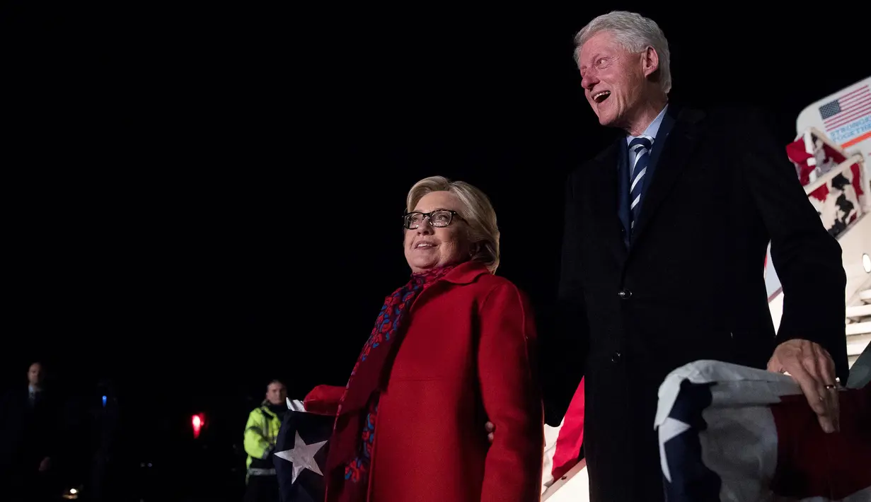 Calon Presiden AS dari Partai Demokrat, Hillary Clinton didampingi suaminya saat tiba di Westchester County Airport di White Plains, New York, AS, Selasa (8/11). (AP Photo / Andrew Harnik)
