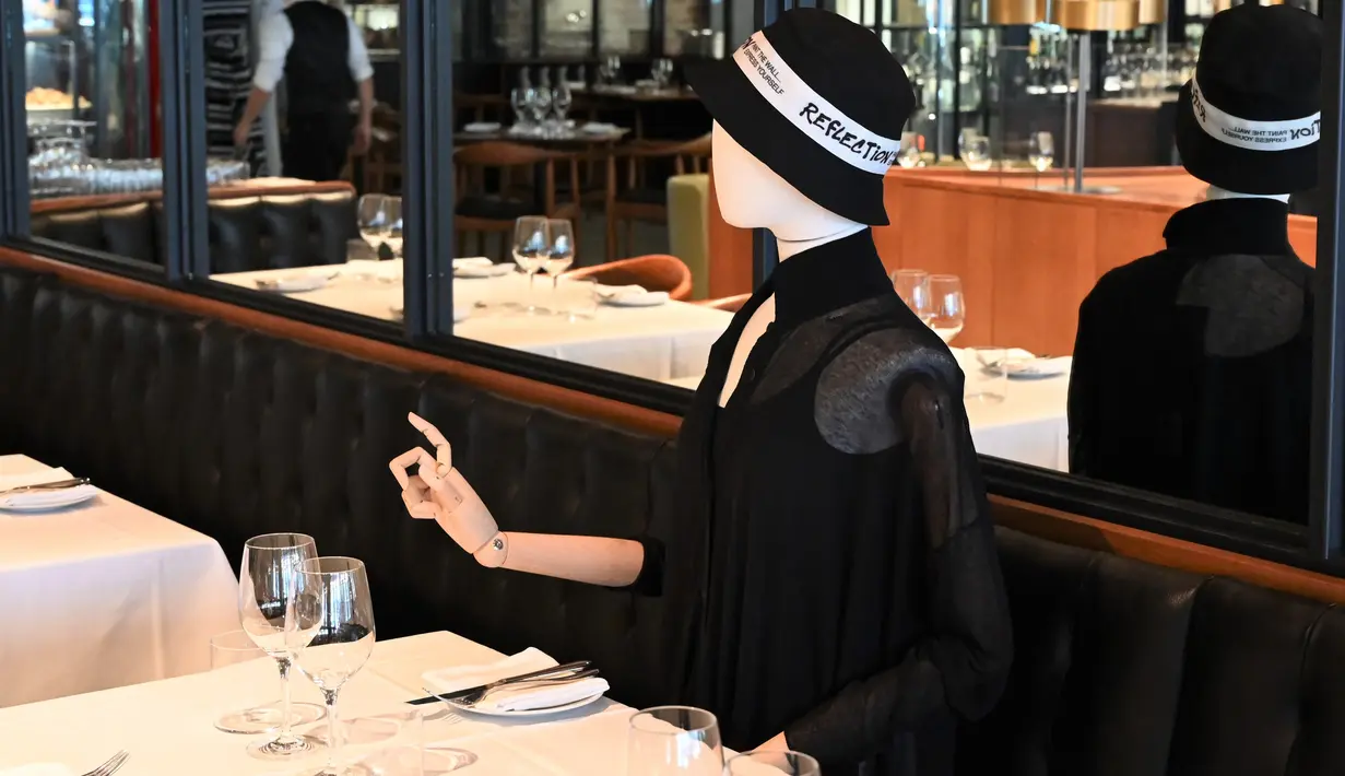 Boneka maneken diletakkan di meja untuk menjaga jarak di sebuah restoran di Old Montreal, Kanada pada 10 Juli 2020. Restoran ini menempatkan maneken untuk menjaga jarak konsumen dan didandani dengan baju-baju keluaran terkini yang dapat dibeli pengunjung setelah makan. (Eric THOMAS/AFP)