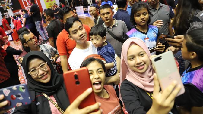 Warga berebut selfie dengan Jhan Ethes Srinarendra dan sang ayah Gibran Rakabuming Raka di final Piala Presiden 2019 yang berlangsung di GOR Sritex, Solo, Minggu (24/11/2019) (Tim Media Piala Presiden 2019)