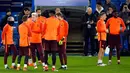 Para pemain Barcelona berbincang saat mengikuti sesi latihan di stadion Stamford Bridge di London, (19/2). Barcelona akan menghadapi Chelsea pada babak 16 besar Liga Champions. (AP Photo/Alastair Grant)