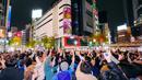Orang-orang merayakan kemenangan timnas Jepang saat melawan Jerman di Piala Dunia Qatar 2022 di persimpangan Shibuya, Tokyo, Jepang, Kamis (24/11/2022). Jepang membuka sejarah baru untuk pertama kalinya karena mampu mengalahkan Jerman yang menyandang status empat kali juara Piala Dunia. (Kyodo News via AP)