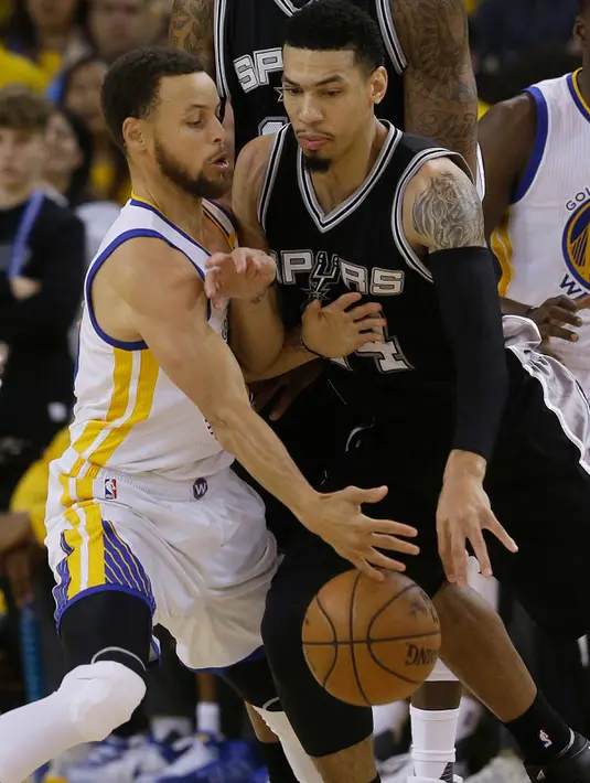 Pemain Golden State Wariors, Stephen Curry berusaha merebut bola yang dibawa pemain Spurs, Danny Green di gim pertama final Wilayah Barat playoffs NBA 2017 di Oakland, California (14/5). (AP Photo/Jeff Chiu)