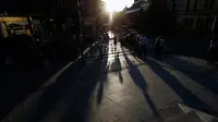 Orang-orang berjalan selama matahari terbenam di pusat kota Belgrade, Serbia, (29/5). Para ahli meteorologi meramalkan cuaca cerah di Serbia akan melanda beberapa hari mendatang. (AP Photo / Darko Vojinovic)