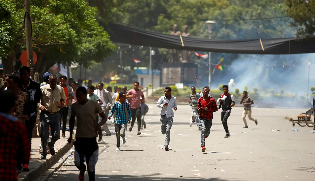 Demonstran berlari saat gas air mata dilepaskan polisi di kota Bishoftu, Ethiopia, Ahad (02/10). Pemerintah Ethiopia menyatakan 52 orang tewas dan banyak lainnya terluka. (REUTERS/Tiksa Negeri) 