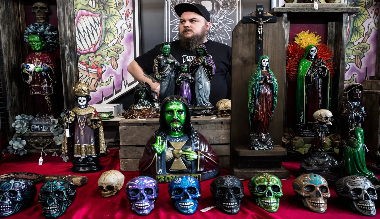 Seorang pria menjual patung di sebuah stan Paris Tattoo Convention di Grand Halle de la Villette, Paris, Prancis, Jumat (9/3). Paris Tattoo Convention tahun ini merupakan yang kedelapan. (Philippe LOPEZ/AFP)
