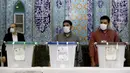 Pejabat pemilihan Iran menunggu pemilih selama pemilihan presiden di sebuah tempat pemungutan suara di Teheran, Iran, Jumat (18/6/2021). Warga Iran mulai memberikan suaranya dalam pemilihan presiden. (AP Photo/Ebrahim Noroozi)