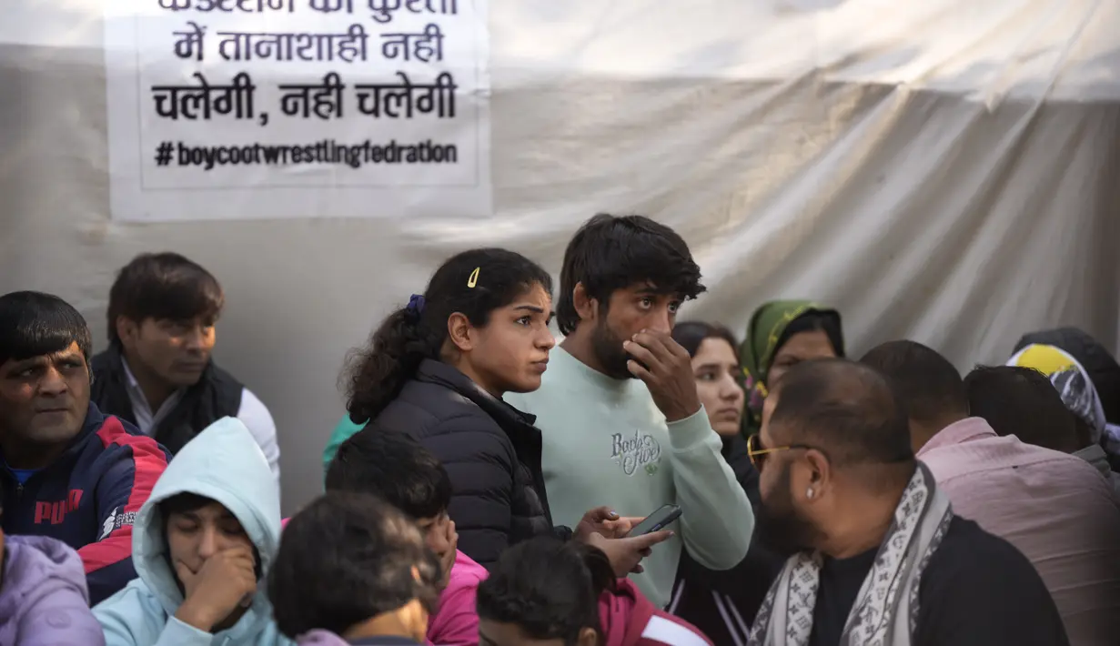 Sakshi Malik, pegulat India yang memenangkan medali perunggu di Olimpiade Musim Panas 2016, (kedua kiri) dan Bajrang Punia, yang memenangkan medali Perunggu di Olimpiade Tokyo 2020 (kiri) berpartisipasi dengan pegulat lain dalam protes terhadap Presiden Federasi Gulat India Brijbhushan Sharan Singh dan pejabat lainnya di New Delhi, India, Jumat (20/1/2023). Pegulat top India memimpin protes di dekat gedung parlemen menuduh presiden federasi dan pelatih melakukan pelecehan seksual dan mental terhadap pegulat muda. (AP Photo/Manish Swarup)