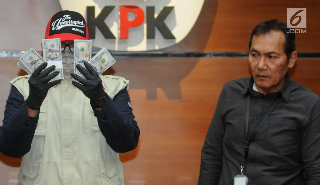 Petugas disaksikan Wakil Pimpinan KPK Saut Situmorang menunjukkan barang bukti uang sebesar USD 30 ribu hasil OTT kasus dugaan suap kuota impor ikan salem atau kan frozen pacific di Gedung KPK, Jakarta, Selasa (24/09/2019). KPK menetapkan dua tersangka. (merdeka.com/Dwi Narwoko)