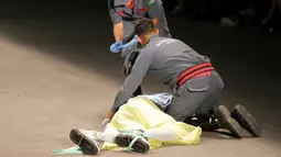 Petugas medis berusaha menyelamatkan model Tales Cotta saat terjatuh di catwalk Sao Paulo Fashion Week, Sao Paulo, Brasil, 27 April 2019. Model berusia 26 tahun tersebut tiba-tiba ambruk dan tidak bangkit lagi. (REUTERS/Leco Viana)
