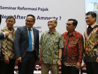 Dirut Bank Mandiri Kartika Wirjoatmodjo (tengah) berbincang dengan narasumber saat Seminar Reformasi Pajak di Jakarta, Senin (30/10). Seminar ini mengupas isu-isu yang mewarnai kelanjutan proses reformasi di bidang perpajakan. (Liputan6.com/Angga Yuniar)