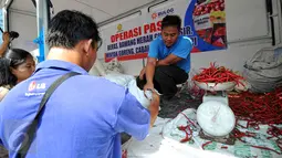 Petugas Bulog melayani pembeli saat menggelar Operasi Pasar Bulog 2015 di kawasan Pasar Benhil, Jakarta, Jumat (26/6/2015). Operasi pasar ini untuk menjaga stabilitas harga sembako di bulan Ramadan. (Liputan6.com/Yoppy Renato)