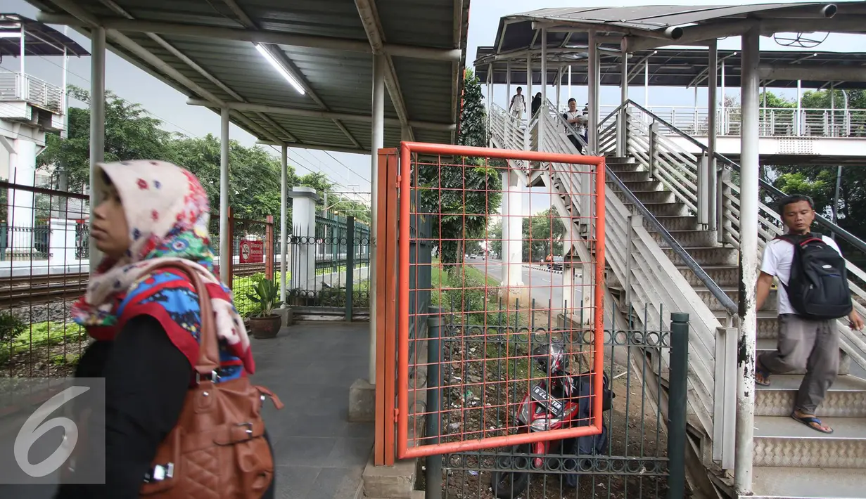 Warga menuruni tangga Jembatan Penyeberangan Orang di Tanjung Barat, Jakarta, Jumat (11/11). Buruknya desain menyebabkan JPO tersebut tidak tersambung, sehingga warga harus membeli tiket kereta jika ingin menyeberang. (Liputan6.com/Immanuel Antonius)