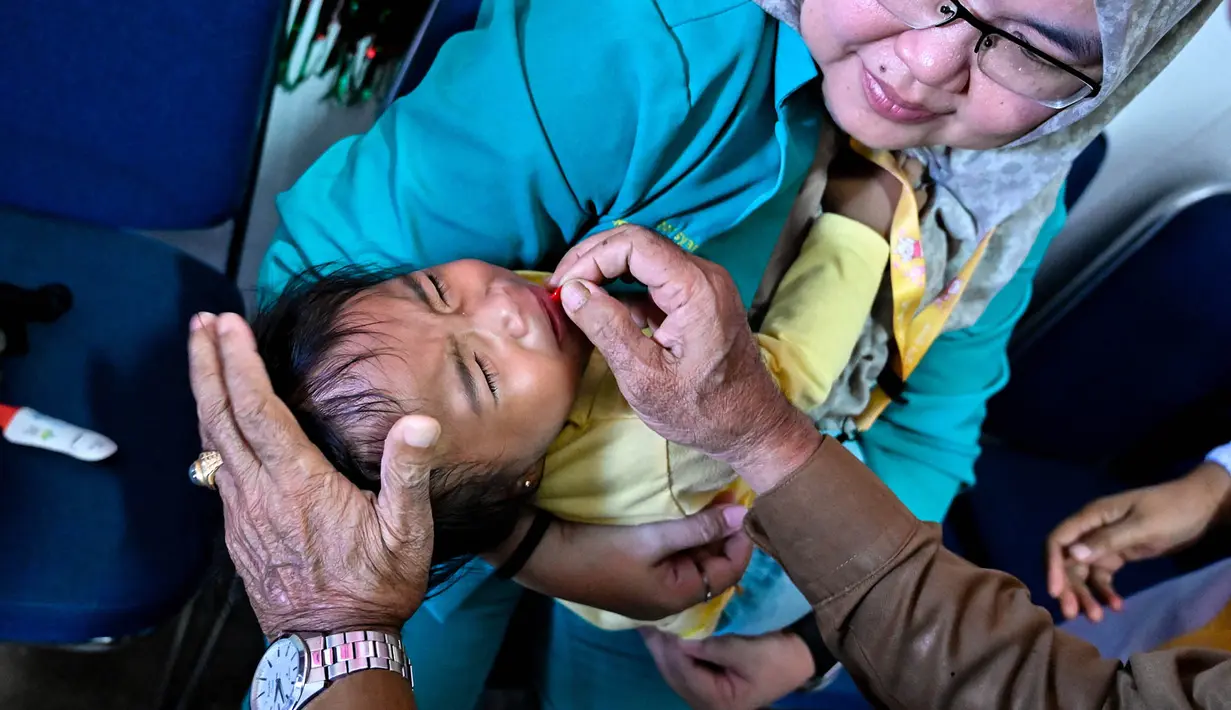 Petugas kesehatan  memberikan suplemen vitamin A kepada bayi dalam program pemeriksaan kesehatan bulanan untuk anak-anak di sebuah pusat layanan terpadu di Banda Aceh, Senin,  10 Agustus 2026. (AFP/ Chaideer Mahyuddin)