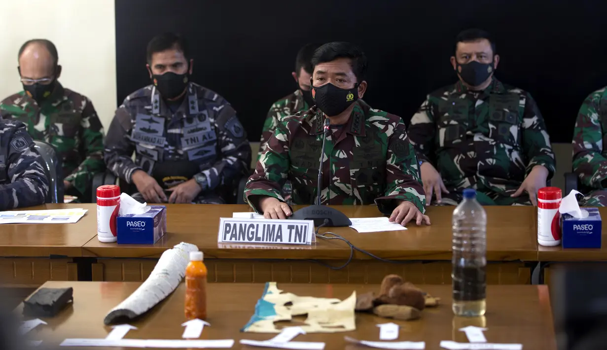 Panglima TNI Hadi Tjahjanto (tengah) menyampaikan keterangan dan menunjukkan puing-puing yang ditemukan dalam operasi pencarian kapal selam KRI Nanggala 402 di Pangkalan Udara Militer Ngurah Rai, Bali, Sabtu (24/4/2021). KRI Nanggala 402 dinyatakan tenggelam atau subsunk. (AP Photo/Firdia Lisnawati)