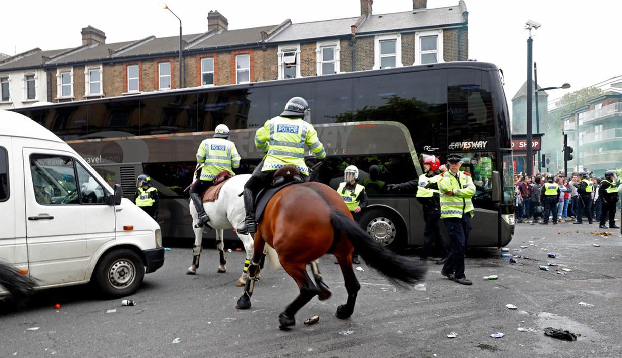 Polisi berkuda menghalau suporter saat bus Manchester United melintas jelang laga melawan West Ham United di Boleyn Ground, London, Rabu (11/5/2016) dini hari WIB. (Reuters/Eddie Keogh)