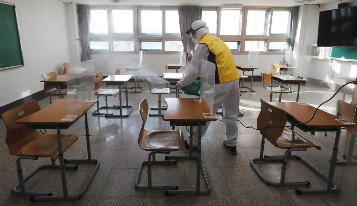 Petugas kesehatan mendisinfeksi ruang kelas untuk ujian masuk perguruan tinggi di Seoul, Korea Selatan, Selasa (1/12/2020). Sekitar 490.000 siswa lulusan sekolah menengah atas di Korea Selatan akan menjalani Tes Kemampuan Skolastik Perguruan Tinggi pada 3 Desember 2020. (AP Photo/Ahn Young-joon)