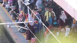 Antrean calon penumpang saat menunggu KRL Commuter Line di Stasiun Tanah Abang, Jakarta, Sabtu (7/3/2020). Masuknya virus Corona atau Covid-19 di Indonesia belum mempengaruhi minat masyarakat untuk tetap bepergian menggunakan transportasi umum. (Liputan6.com/Angga Yuniar)