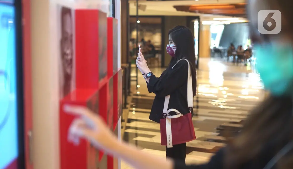 Pengunjung membeli masker dari mesin penjual otomatis (vending machine) di Senayan City, Jakarta, Jumat (6/11/2020). Penyediaan dua mesin penjual masker otomatis tersebut bertujuan memudahkan pengunjung untuk dapat membeli masker di dalam mal. (Liputan6.com/Immanuel Antonius)