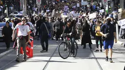 Ratusan pengunjuk rasa berbaris di jalan selama protes anti-lockdown di Melbourne, Australia, Sabtu (21/8/2021). Para pengunjuk rasa berunjuk rasa menentang pembatasan pemerintah yang ditempatkan dalam upaya mengurangi wabah COVID-19. (James Ross/AAP Image via AP)