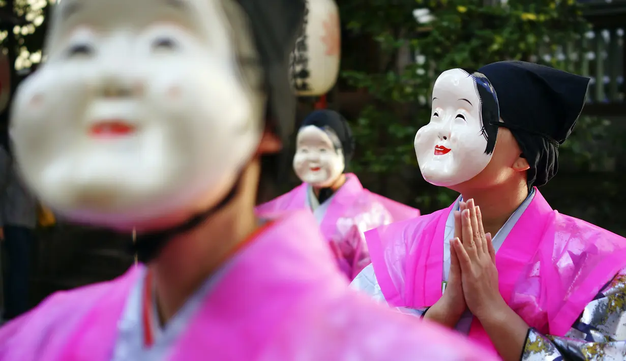 Seniman mengenakan Otafuku tradisional Jepang atau topeng Okame selama Festival Konpira di kuil Kotohiragu di distrik bisnis Toranomon di Tokyo (10/1/2020). Selain topeng tradisional, seniman pakaian tradisional khas negeri tersebut. (AP Photo/Eugene Hoshiko)