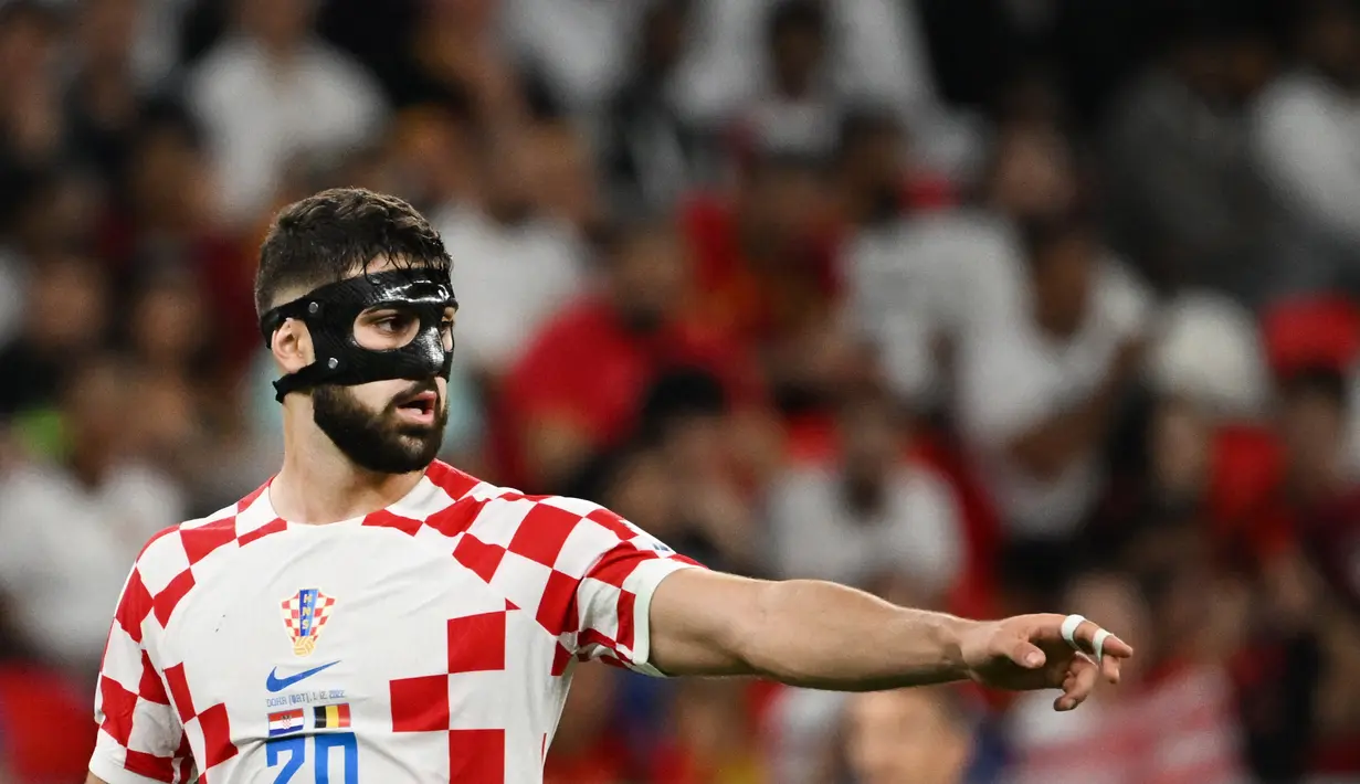Bek Kroasia #20 Josko Gvardiol memberi isyarat selama laga terakhir Grup F Piala Dunia 2022 menghadapi Belgia di Stadion Ahmad bin Ali, Kamis (1/12/2022). Bek tengah kidal itu selalu menghadirkan gangguan bagi penyerang lawan. (Photo by OZAN KOSE / AFP)