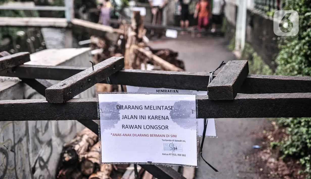 Akses jalan di sekitar lokasi turap longsor terpaksa ditutup di Batu Ampar, Kramat Jati, Jakarta, Selasa (23/2/2021). Beruntung tidak ada korban jiwa dalam kejadian ini namun warga setempat terpaksa menutup akses jalan di sekitar lokasi guna mencegah longsor susulan.  (merdeka.com/Iqbal S. Nugroho)
