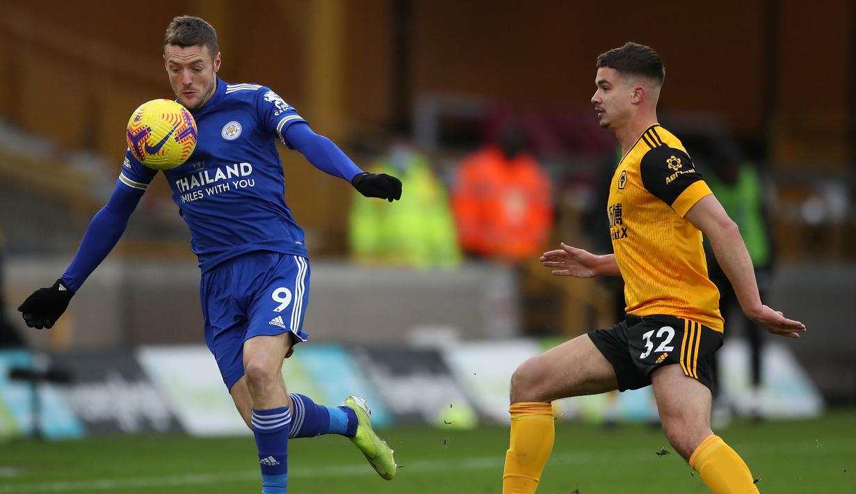 Striker Leicester City, Jamie Vardy (kiri) menguasai bola dibayangi gelandang Wolverhampton Wanderers, Leander Dendoncker dalam laga lanjutan Liga Inggris 2020/21 pekan ke-23 di Molineux Stadium, Minggu (7/2/2021). Leicester bermain imbang 0-0 dengan Wolverhampton. (AFP/Nick Potts/Pool)