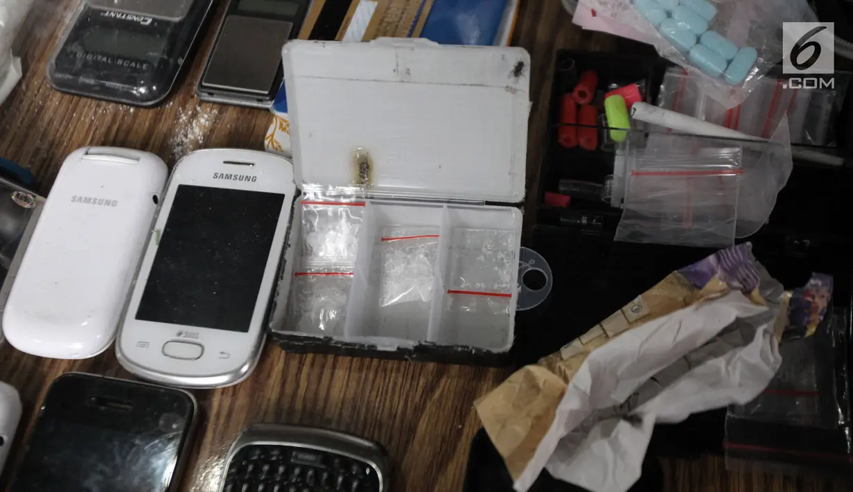 Sejumlah telepon genggam dan paket narkoba yang berhasil diamankan petugas saat penggerebekan di Kampung Ambon, Cengkareng, Jakarta, Rabu (24/1). Petugas mengamankan sabu, ganja, bong, timbangan. (Liputan6.com/Arya Manggala)
