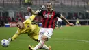 Pemain AC Milan Zlatan Ibrahimovic (kanan) menendang bola saat penjaga gawang Bologna Lukasz Skorupski mencoba menghentikannya pada pertandingan Serie A di Stadion San Siro, Milan, Italia, Senin (21/9/2020). AC Milan menaklukkan Bologna 2-0. (AP Photo/Antonio Calanni)