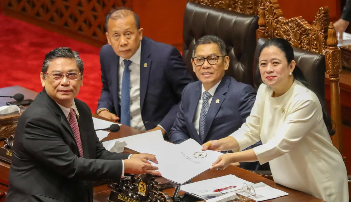 Rapat dipimpin oleh Ketua DPR RI Puan Maharani yang didampingi Wakil Ketua DPR yang lain, seperti Sufmi Dasco Ahmad, Saan Mustopa, dan Adies Kadir. Tampak dalam foto, Ketua Komisi I DPR RI yang juga Ketua Panja RUU TNI, Utut Adianto (kiri) menyerahkan naskah Rancangan Undang-Undang Tentara Nasional Indonesia (RUU TNI) kepada Ketua DPR RI Puan Maharani di Gedung DPR RI di Jakarta pada 20 Maret 2025. (RAQILLA/AFP)