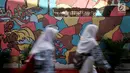 Anak sekolah melintas di depan lukisan tembok atau mural yang menghiasi gang di RT 13 RW 06, Jembatan Lima, Jakarta, Kamis (10/1). Pembuatan mural itu dimaksudkan agar lingkungan menjadi lebih tertata dan indah. (Merdeka.com/Iqbal Nugroho)