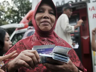 Warga seusai mengambil uang Kartu Lansia Jakarta (KLJ) melalui ATM Bank DKI di Jakarta Islamic Center, Koja, Rabu (24/4). Penerima KLJ mendapatkan Rp 600.000 per bulan sebagai bentuk pemberian bantuan sosial untuk pemenuhan kebutuhan dasar bagi lanjut usia. (merdeka.com/Iqbal S. Nugroho)