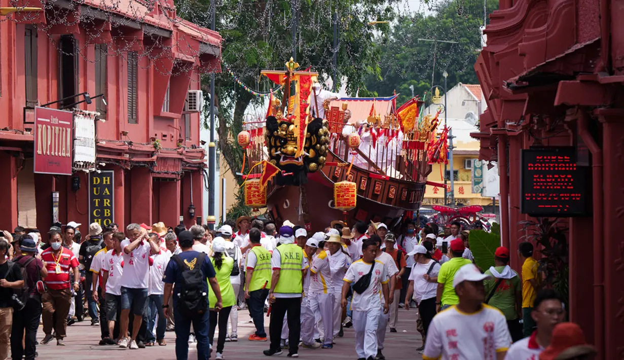 Warga keturunan Tionghoa menarik replika raksasa kapal tongkang kerajaan di Malaka dalam prosesi langka dan penuh warna yang bertujuan untuk mengumpulkan dan mengusir roh jahat. (AP Photo/Vincent Thian)