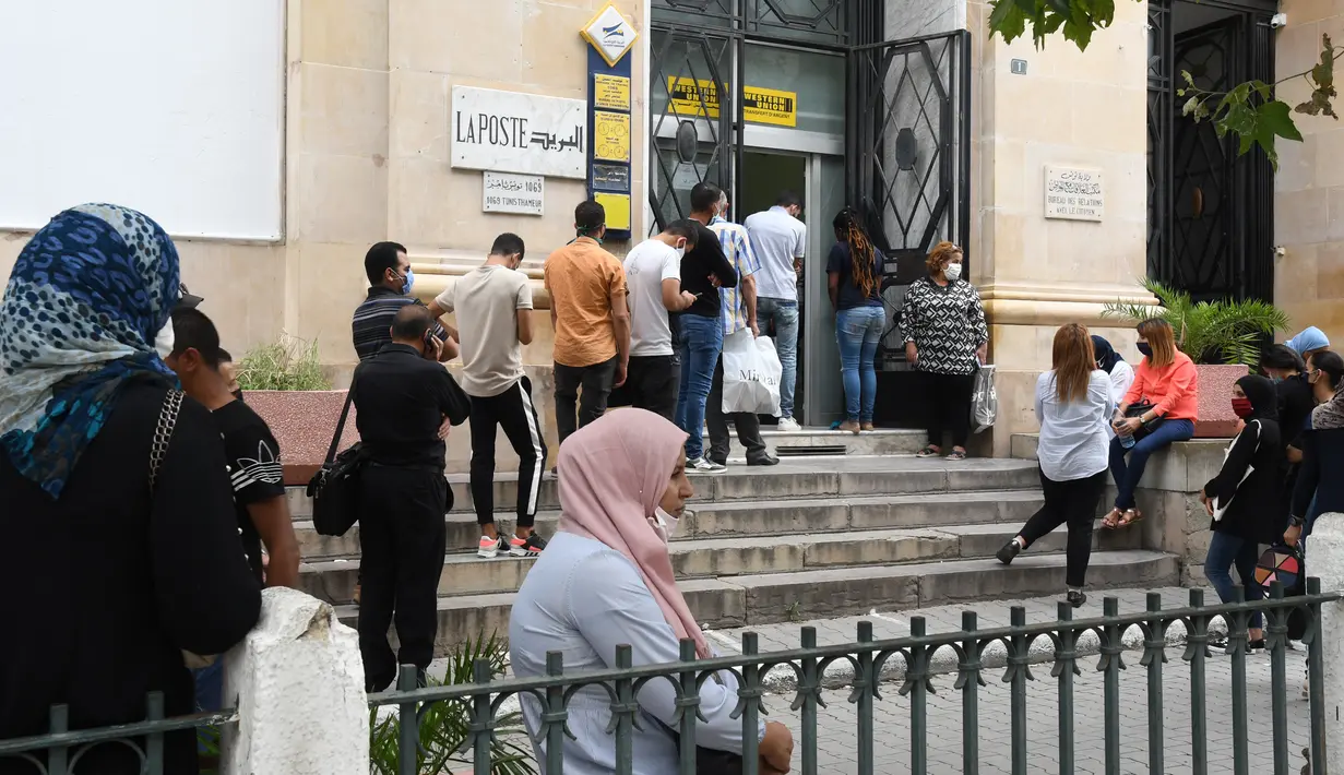 Orang-orang yang mengenakan masker mengantre untuk memasuki kantor pos di Tunis, Tunisia, pada 5 Oktober 2020. Perdana Menteri Tunisia Hichem Mechichi pada 3 Oktober mengumumkan serangkaian langkah untuk membatasi penyebaran cepat COVID-19 di negara tersebut. (Xinhua/Adel Ezzine)