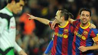 Andres Iniesta dan Xavi, duo pilar di lini tengah Barcelona merayakan gol ketika berhadapan dengan Racing Santander di partai La Liga pada 22 Januari 2011. AFP PHOTO/LLUIS GENE