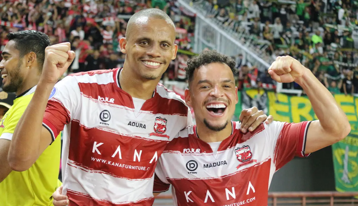 Dua pemain asing Madura United, Cleberson dan Lulinha merayakan hasil positif saat menahan imbang Persebaya Surabaya, Minggu (14/8/2022). (Bola.com/Wahyu Pratama)