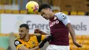 Pemain Aston Villa, Ollie Watkins, duel udara dengan pemain Wolverhampton Wanderers, Romain Saiss, pada laga Liga Inggris di Stadion Molineux, Minggu (13/12/2020). Aston Villa menang dengan skor 0-1. (Tim Keeton/Pool/AFP)