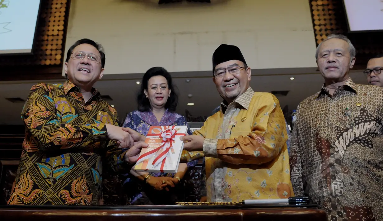 Ketua DPD RI Irman Gusman (kiri) menerima buku ikhtisar hasil pemeriksaan semester ll tahun 2014 dari Ketua BPK RI Harry Azhar Aziz (kedua kanan) usai mengikuti Rapat Paripurna di Komplek Parlemen, Jakarta, Rabu (8/4/2015). (Liputan6.com/Andrian M Tunay)