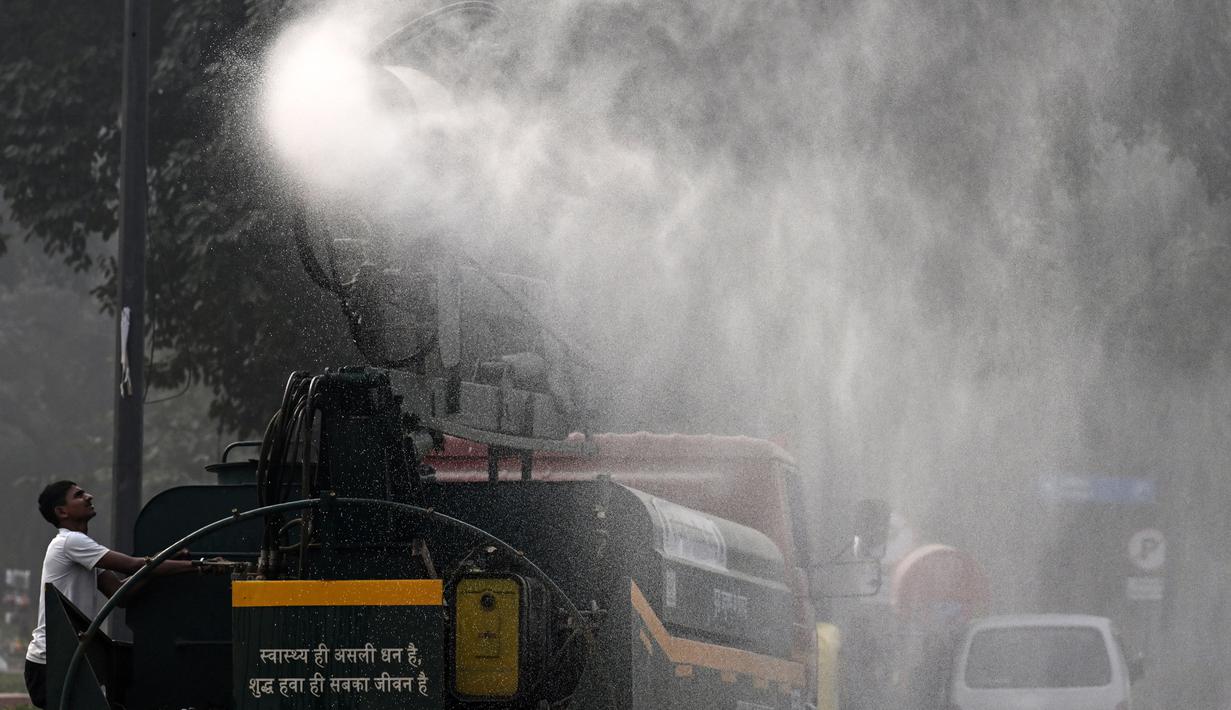 Sebuah kendaraan dari Departemen Pekerjaan Umum (PWD) menyemprotkan air dengan menggunakan penyemprot anti-kabut asap untuk mengurangi polusi udara di New Delhi, India pada 7 November 2024. (Arun SANKAR/AFP)